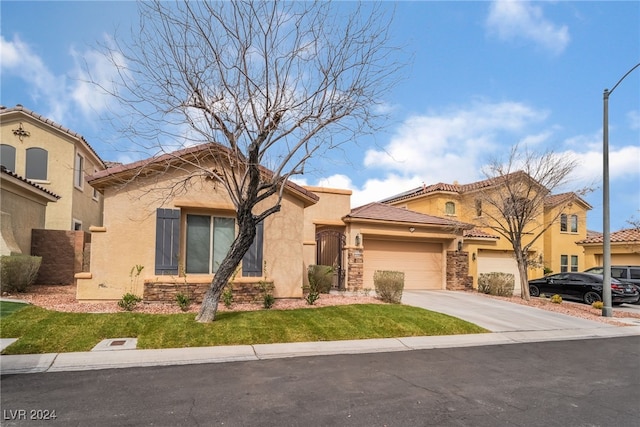 mediterranean / spanish-style house featuring a garage, stone siding, driveway, and stucco siding