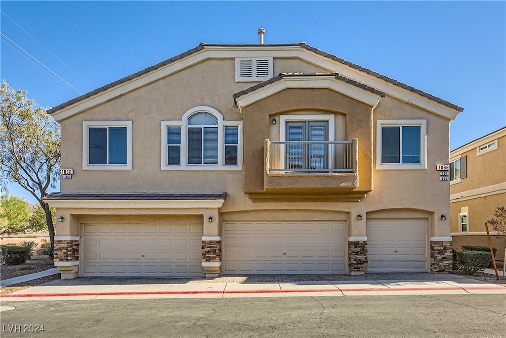 view of front of home featuring a garage and a balcony