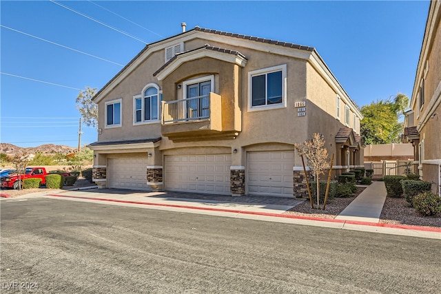 view of front of property featuring a garage, a mountain view, and a balcony