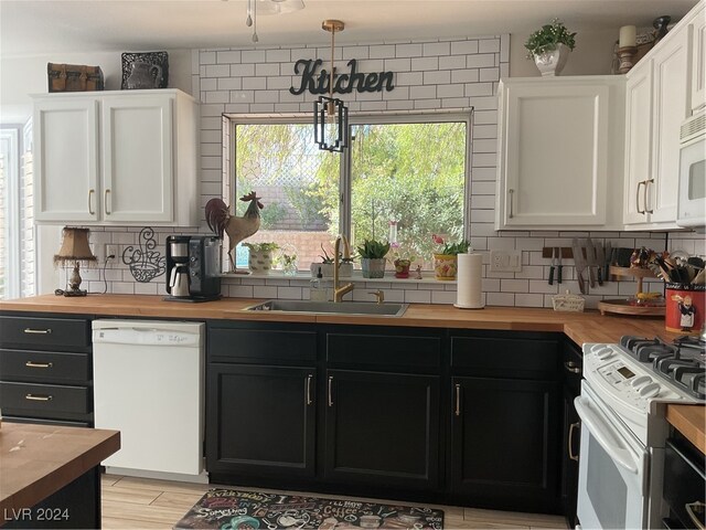 kitchen featuring white cabinets, white appliances, tasteful backsplash, and sink