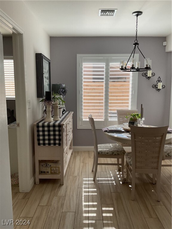 dining room featuring light hardwood / wood-style flooring and a chandelier