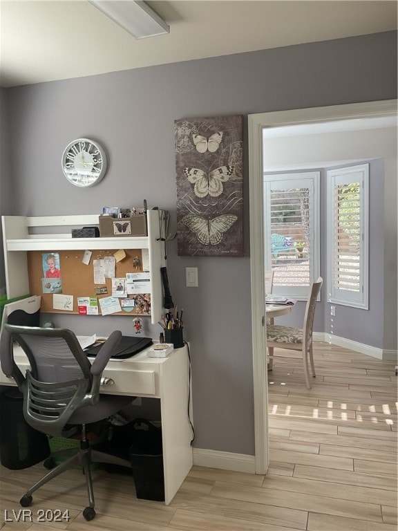 home office with light hardwood / wood-style floors