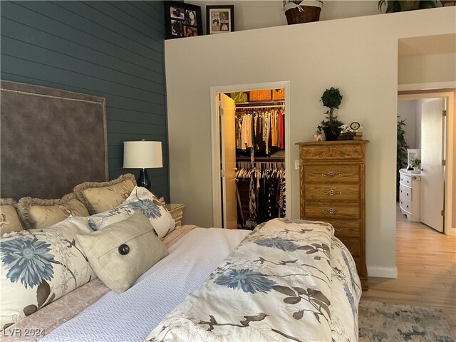 bedroom featuring a spacious closet, light wood-type flooring, and a closet