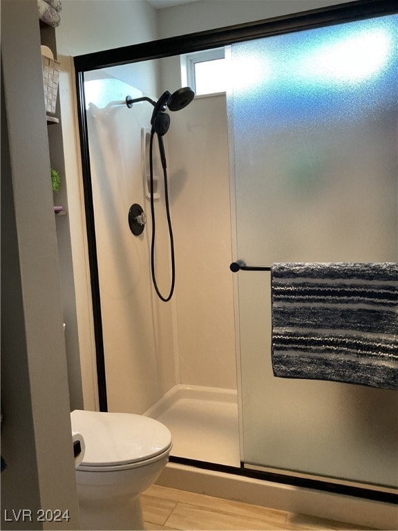 bathroom featuring a shower with door and wood-type flooring