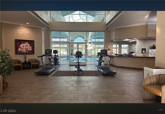 gym with a high ceiling and ornamental molding