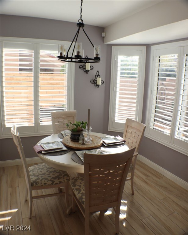 dining room featuring wood-type flooring and an inviting chandelier