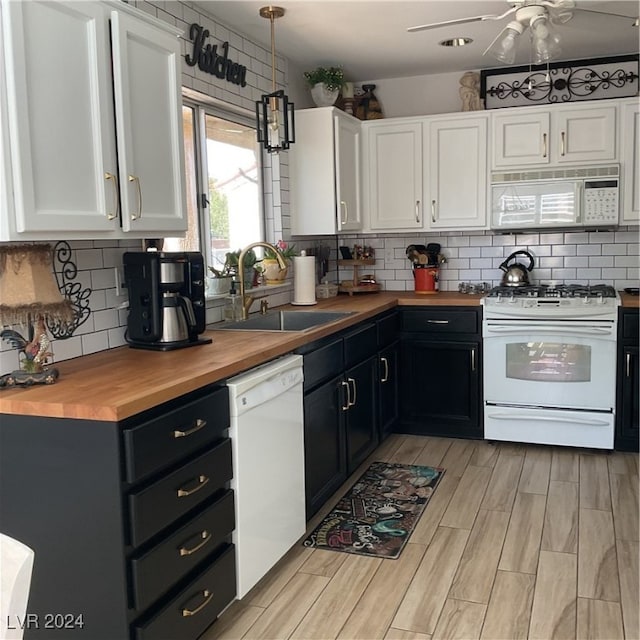 kitchen featuring white cabinets, sink, wooden counters, white appliances, and decorative light fixtures