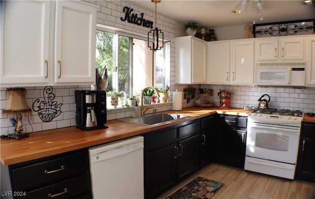 kitchen with white cabinets, white appliances, sink, and butcher block counters