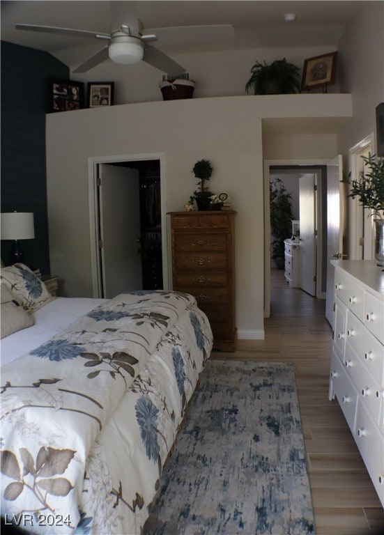 bedroom with a closet, vaulted ceiling, ceiling fan, and hardwood / wood-style flooring