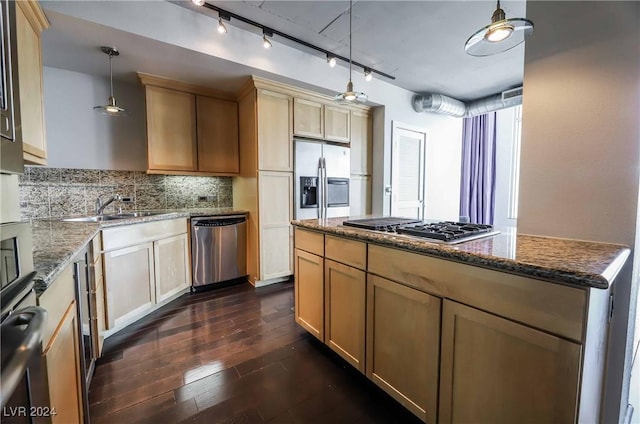 kitchen with sink, stone counters, hanging light fixtures, stainless steel appliances, and a center island