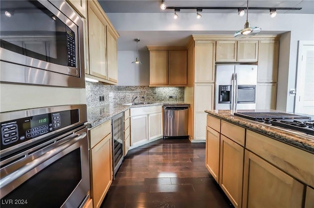 kitchen with appliances with stainless steel finishes, backsplash, dark hardwood / wood-style floors, light stone counters, and decorative light fixtures