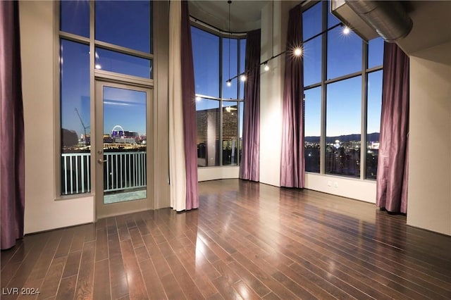 spare room featuring dark hardwood / wood-style floors and a high ceiling