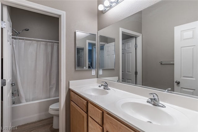 full bathroom featuring shower / bath combo, hardwood / wood-style floors, vanity, and toilet