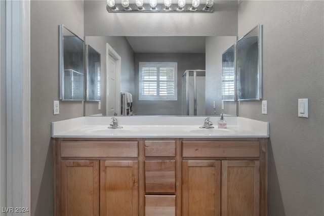 bathroom with a shower with door and vanity