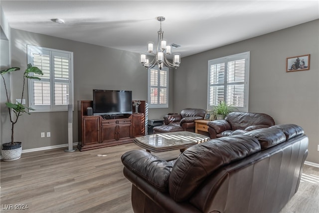 living room with light wood-type flooring and a chandelier