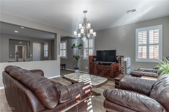 living room with a chandelier and light hardwood / wood-style floors