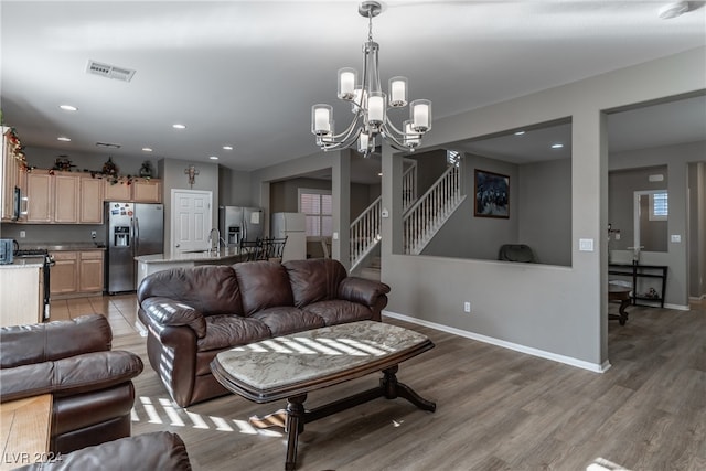 living room with sink, wood-type flooring, and a notable chandelier