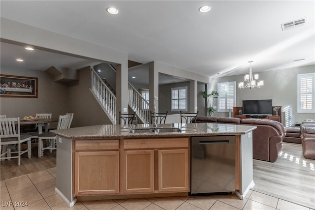 kitchen featuring sink, an inviting chandelier, stainless steel dishwasher, an island with sink, and light wood-type flooring