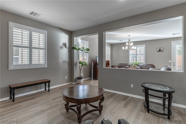 living room featuring a notable chandelier and light hardwood / wood-style flooring