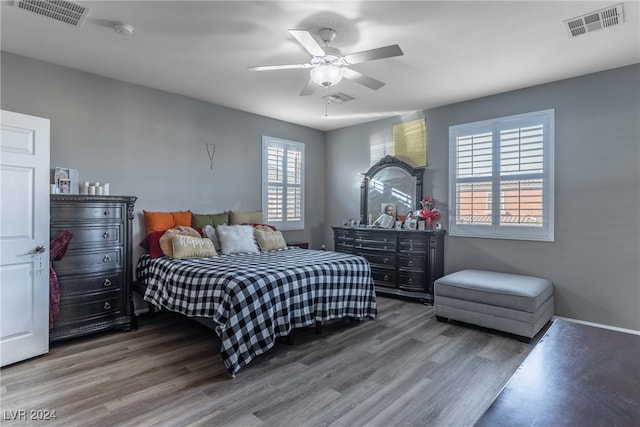 bedroom with wood-type flooring, multiple windows, and ceiling fan