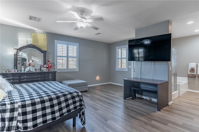 bedroom featuring multiple windows, hardwood / wood-style flooring, and ceiling fan