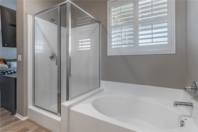 bathroom featuring wood-type flooring and separate shower and tub