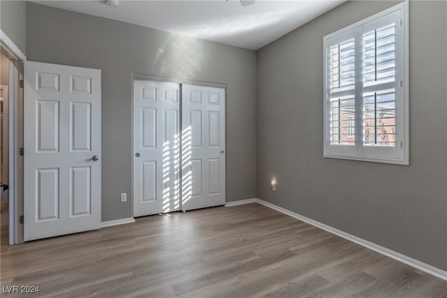 unfurnished bedroom with a closet and light wood-type flooring