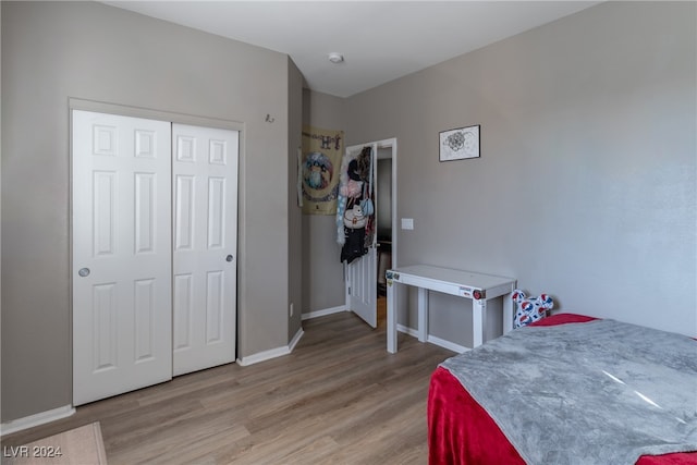 bedroom with light hardwood / wood-style floors and a closet