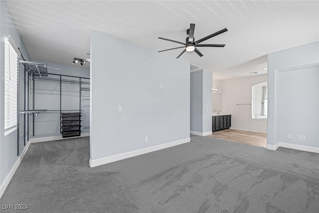 unfurnished living room featuring carpet floors, plenty of natural light, and ceiling fan