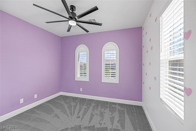 carpeted spare room featuring ceiling fan