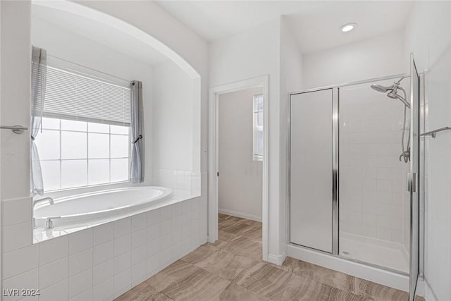 bathroom featuring shower with separate bathtub