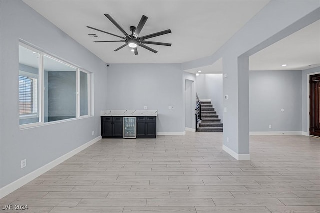 unfurnished living room with light hardwood / wood-style flooring, beverage cooler, and ceiling fan