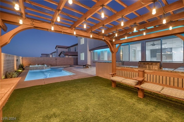 view of swimming pool featuring a yard, a pergola, a patio area, and exterior kitchen