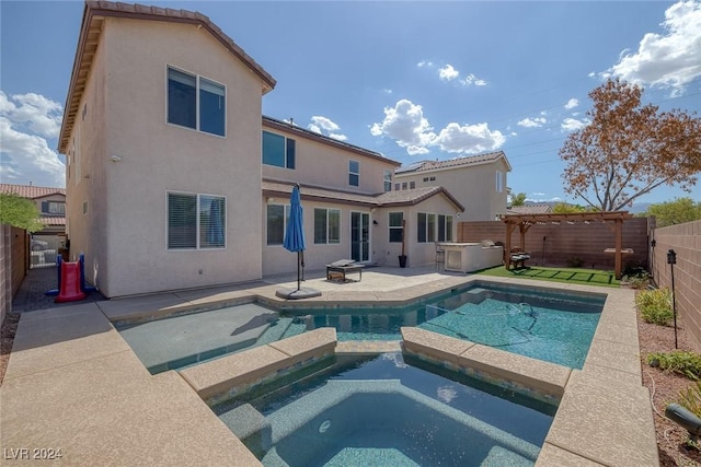 back of house with a swimming pool with hot tub, a pergola, and a patio