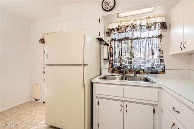 kitchen featuring light tile patterned floors, white fridge, white cabinetry, and sink