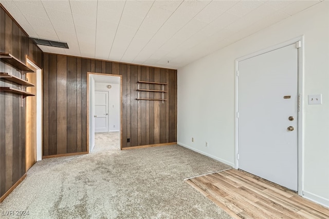 interior space featuring light hardwood / wood-style flooring and wooden walls