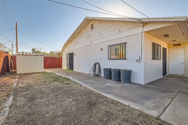 view of side of home featuring a storage unit