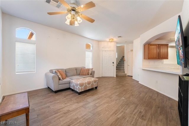 living room with light hardwood / wood-style floors and ceiling fan