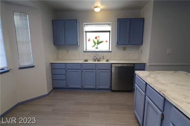 kitchen with blue cabinetry, light wood-type flooring, stainless steel dishwasher, and sink