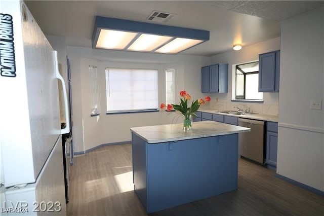 kitchen with white refrigerator, dishwasher, blue cabinetry, dark hardwood / wood-style floors, and a kitchen island