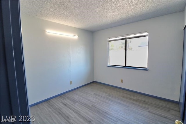 spare room with wood-type flooring and a textured ceiling