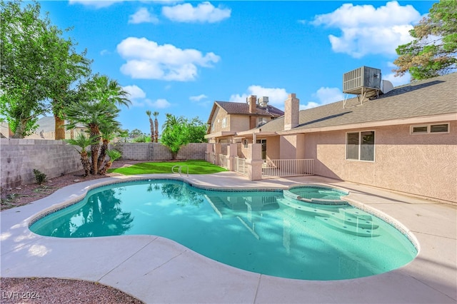 view of pool featuring central air condition unit and an in ground hot tub