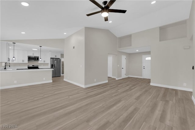 unfurnished living room featuring high vaulted ceiling, ceiling fan, light hardwood / wood-style floors, and sink