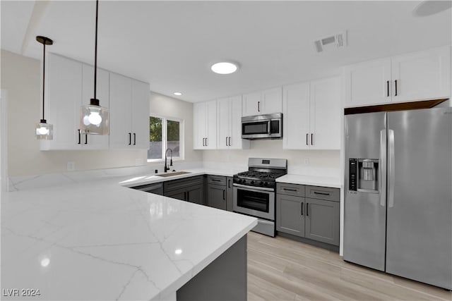 kitchen featuring appliances with stainless steel finishes, gray cabinetry, pendant lighting, sink, and white cabinetry