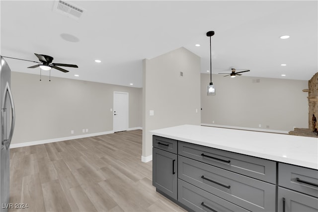 kitchen featuring gray cabinetry, ceiling fan, light hardwood / wood-style floors, and decorative light fixtures