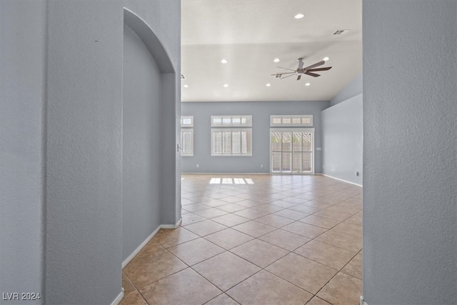 tiled spare room featuring lofted ceiling and ceiling fan