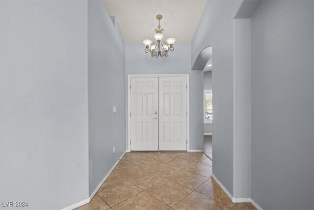 entrance foyer featuring light tile patterned floors and an inviting chandelier