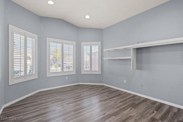 spare room featuring vaulted ceiling and dark hardwood / wood-style flooring