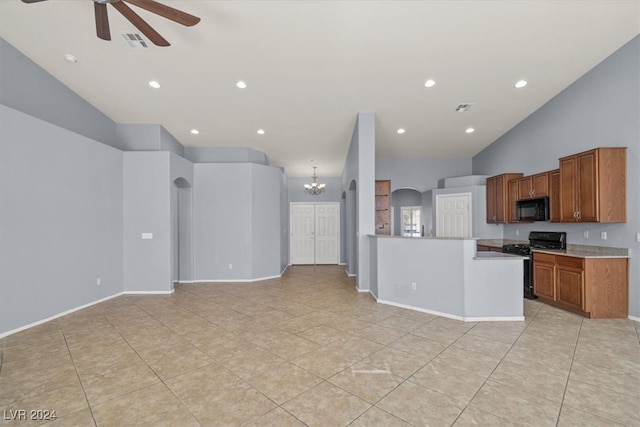 kitchen featuring black appliances, lofted ceiling, light tile patterned floors, and ceiling fan with notable chandelier