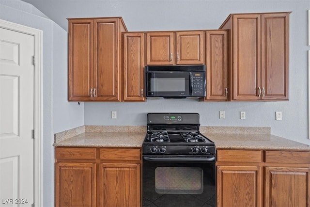 kitchen with black appliances and light stone countertops